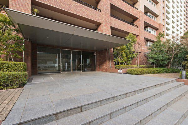 緑と大きな庇が調和する広々としたエントランス。		