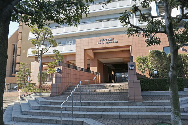 白とブラウンのタイルのコントラストに、施された植栽の緑が映える落ち着いた空間。