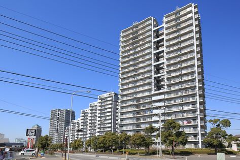 シンプルなオフホワイトの外観で21階建てのタワーフォルム。		