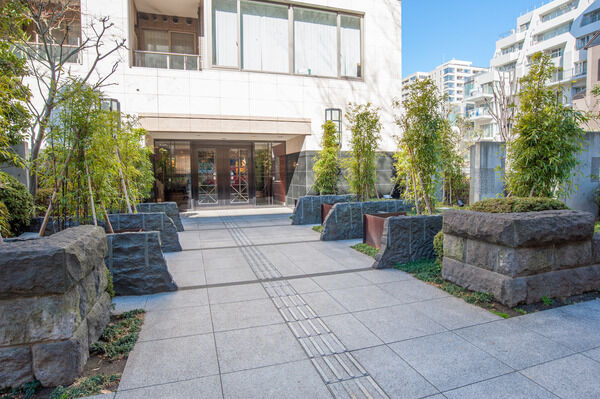 左右に石垣を積み黒竹や樹木を列植したエントランスへのアプローチ。