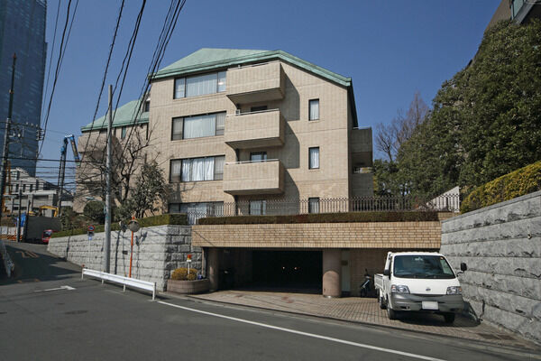 シャッター完備の駐車場は地下にある平置き型。晴天の日には手前のスペースで洗車も。