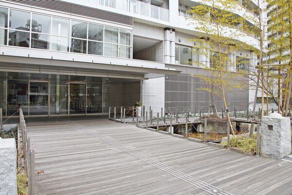 修景池を設けウッドデッキの広いブリッジを渡したグランドエントランス。		