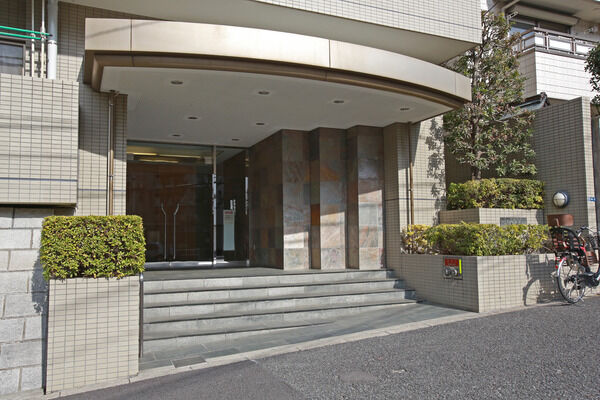 タイル張りの外壁と、石造りのエントランスが好対照。