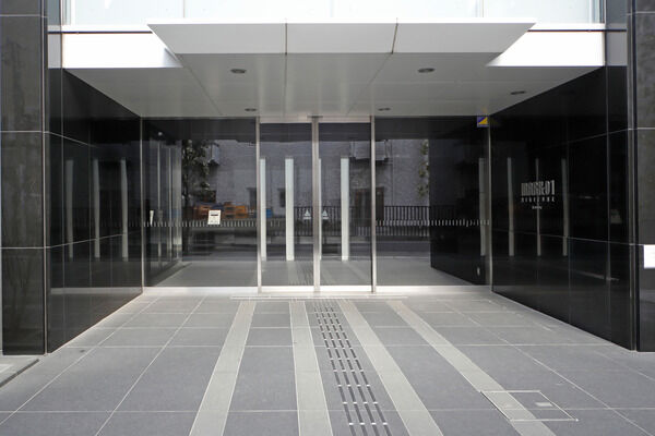 黒の御影石とグレーのタイルが調和したエントランスアプローチ。		