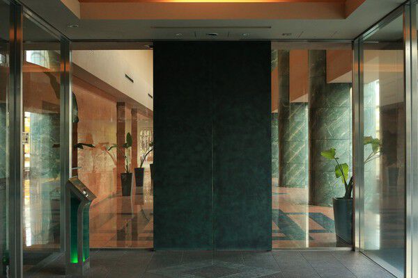 鏡面に輝くロッソの大理石を床面に設えらえたラグジュアリーなエントランス空間。		