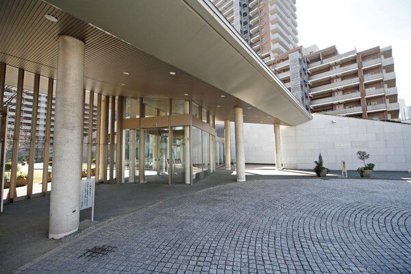 ガラスウォールと植栽で街並みに融け込み、ルーフを包み込むメインエントランス。