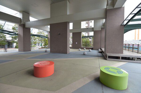 川沿いの風が吹き抜ける1階ピロティには、川床をイメージしたベンチ付き。		