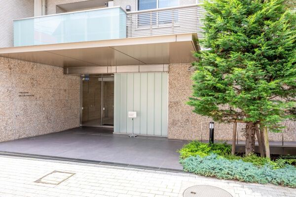 シャープなアルミ素材の庇と重厚な質感の大理石がスマートに演出するエントランス。		