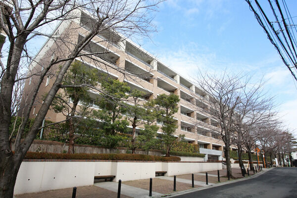 【パークシティ弦巻】東側外観。歩道に沿って植えられた桜並木と植栽が美しい風景を創っています。		