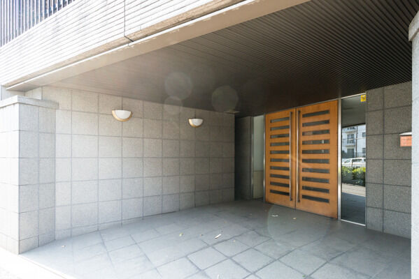 壁のブラケットライトがエントランスを穏やかな光で照らす。