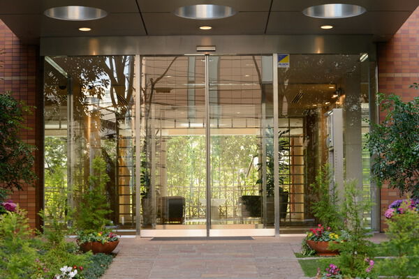 エントランスホールは、建物周辺が見渡せる大きなガラスで、自然との一体感を表現。 エントランスホールは、建物周辺が見渡せる大きなガラスで、自然との一体感を表現。