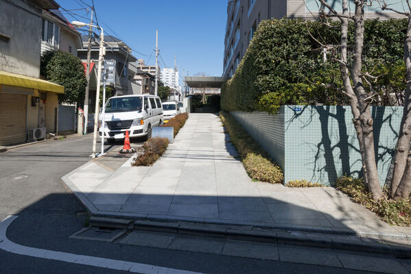【笹塚パークホームズ】花崗岩を貼ったなだらかなスロープ。脇に見える植栽が印象的。