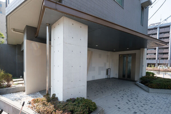 【代々木公園パークホームズ】植栽に囲まれたエントランスは、弧を描くように設計されハイセンスなイメージ。
