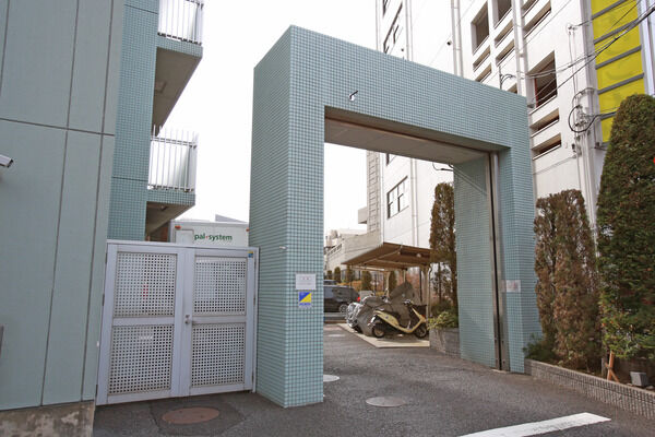 外壁と同じミントグリーンで統一された駐車場・駐輪場への入り口。