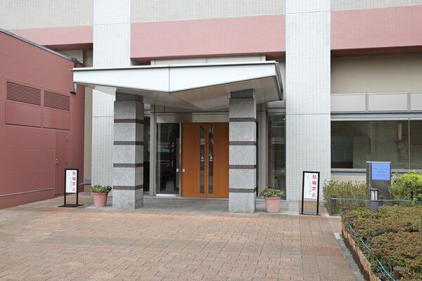 タイル貼りの両側を緑と花が彩るエントランスアプローチ。		