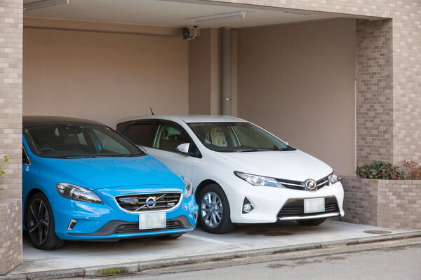 道路に面して2台分の屋内駐車場を設置。さらに敷地外にも駐車場を設置。