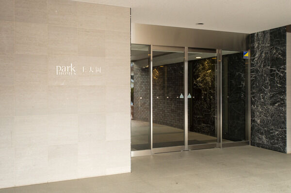 シックな大理石の壁と、スリット照明のコントラストが美しいロビー。