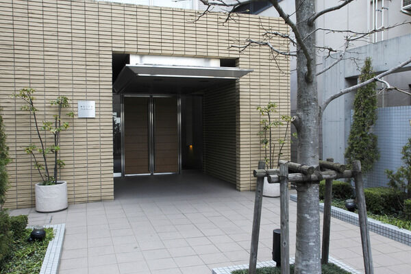 奥に配された木調の両開き扉は重厚感があり、雨風を防ぐ配慮がされています。