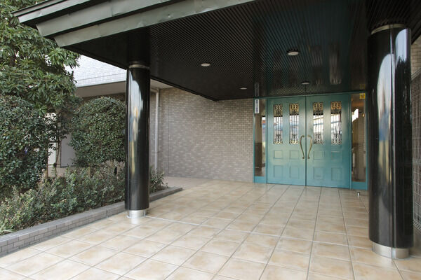 2本の円柱と緑色のファサードが印象的なエントランス。