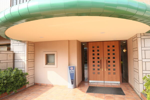 グリーンのひさしが印象的なエントランス。ウッドのドアとともに温かさを感じます。