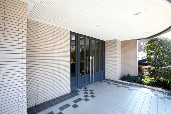 気品あふれるエントランス。植栽の緑と落ち着いた色調のタイル貼りの床が映えます。		