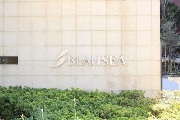 “上質なカジュアル”を予感させる緑と調和したエントランスプレート。