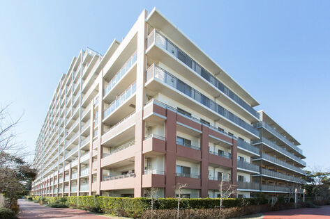 住宅街の高台に位置する14階建てのベージュを基調カラーとした外観。