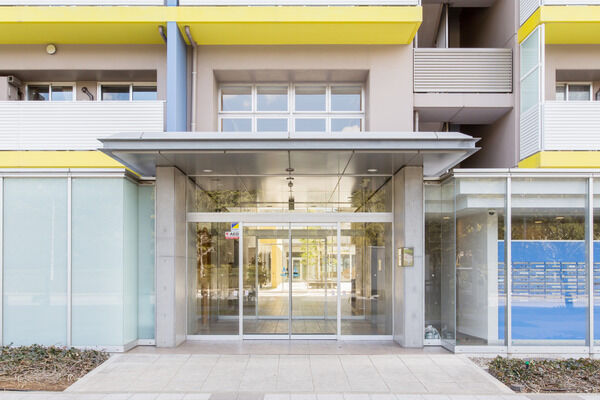 メインエントランスは、建物と色彩を揃えたシンプルで優しいデザイン。		 メインエントランスは、建物と色彩を揃えたシンプルで優しいデザイン。