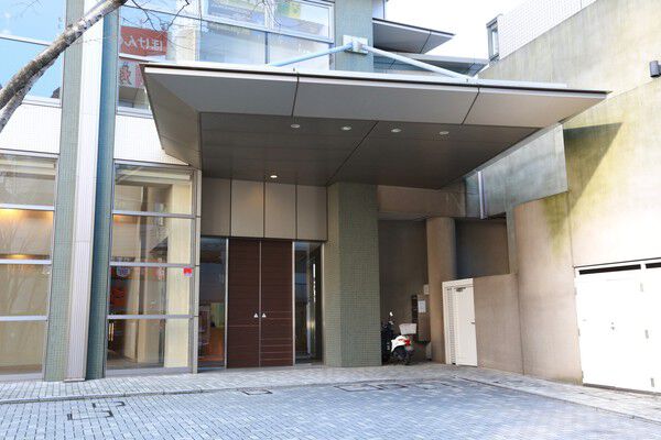 メタリック調の大きなキャノピーが目を引く、車寄せのあるサブエントランス。