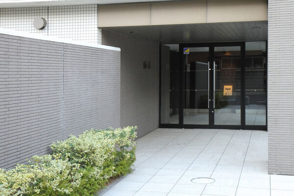 ボーダータイルの受け壁に導かれてはじまるアプローチ空間。