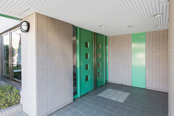 茶系のタイルの中に、緑の扉が映え、高級感を感じさせる。		