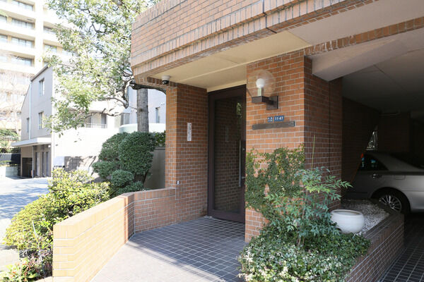 共用玄関はアプローチの先。ドアはオートロックシステムを採用しています。