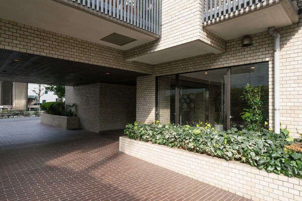 大きなガラス窓から差し込む光がエントランスホールを照らす。		