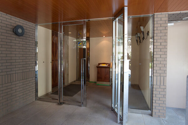 軒天の桜材やさび石仕上げの床が住まう人を優しく出迎える開かれたエントランス。		