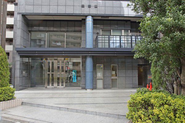 青銅色の円柱がアクセントのエントランス。		