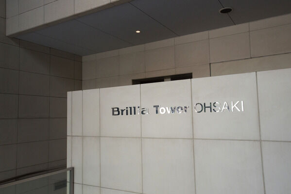 ライムストーン調タイルに映えるシルバーのネーム。都会的で洗練された雰囲気です。