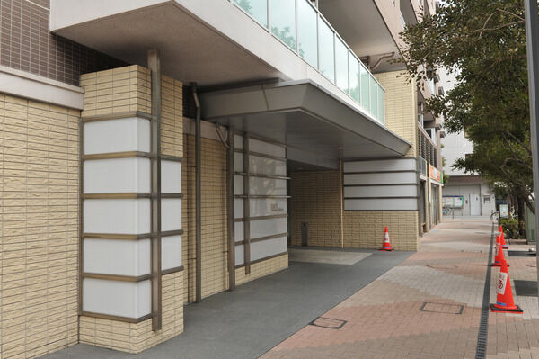 道を行き交う人に優しい印象を与える壁面タイルが続くアプローチ。		