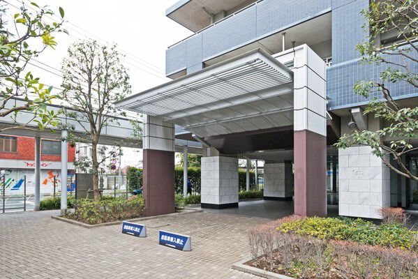 エントランスのアプローチはタイルの床に大理石の柱を配したピロティを設置。		