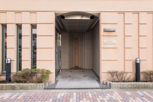 グレーの外壁と好対照の、淡いベージュで彩ったエントランス。		