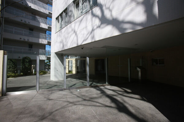 壁面には透明ガラススクリーンを採用。敷地内の植栽が街並の景観に参加しています。		