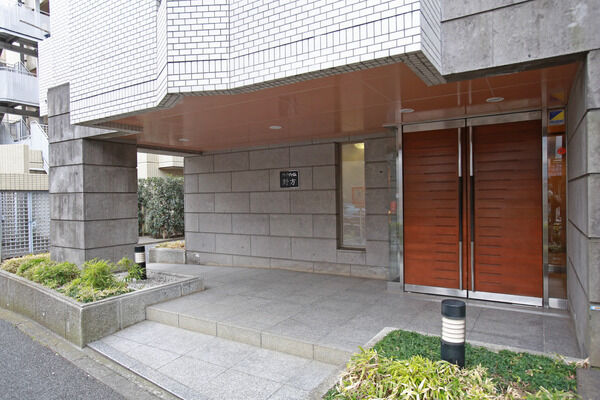 コンクリートの重厚感と木のぬくもりが見事に調和したエントランス。		