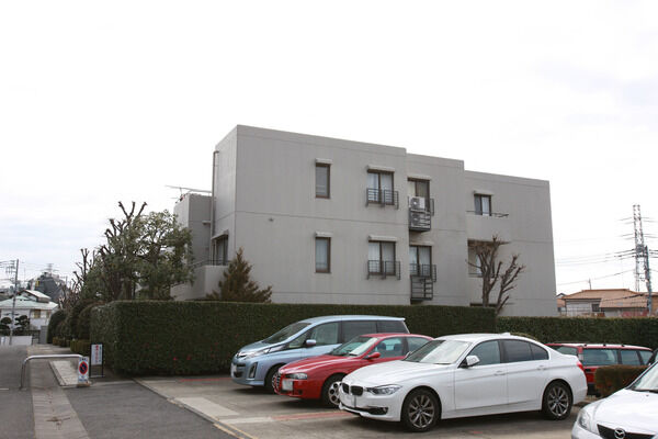 建物北西にあるスペースは植え込みに囲まれた平面駐車場。		