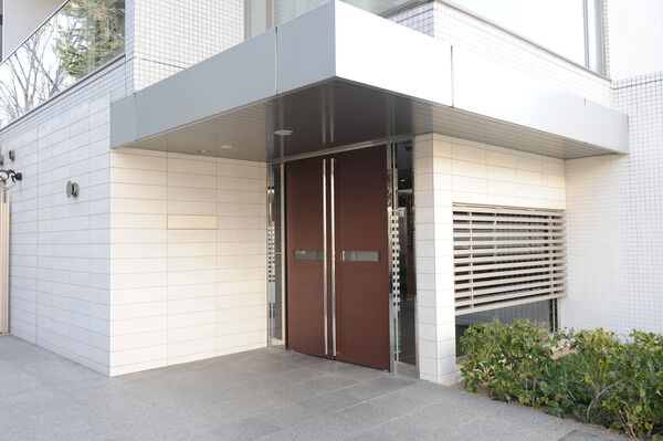 木調ルーバーと間接照明でギャラリーのようにデザインされたエントランス。