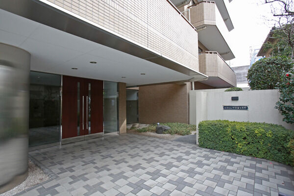 エントランス前には落ち着いた中庭を設け、エレガントな中に温もりのある雰囲気。