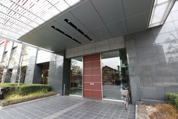 エントランスへ続くアプローチに木々が植えられ、心地よい空間に。