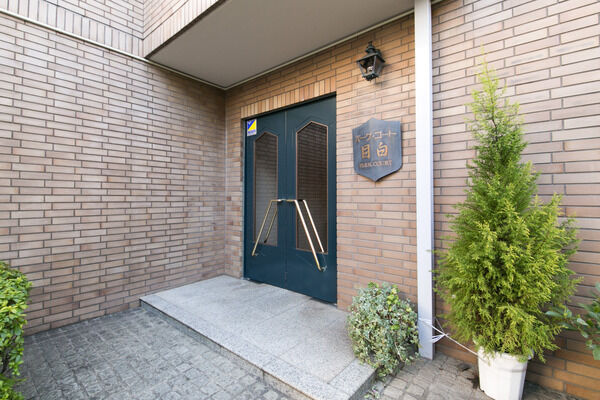 シックな色合いのドアと周りを囲むレンガで、エレガントなイメージの玄関周り。		