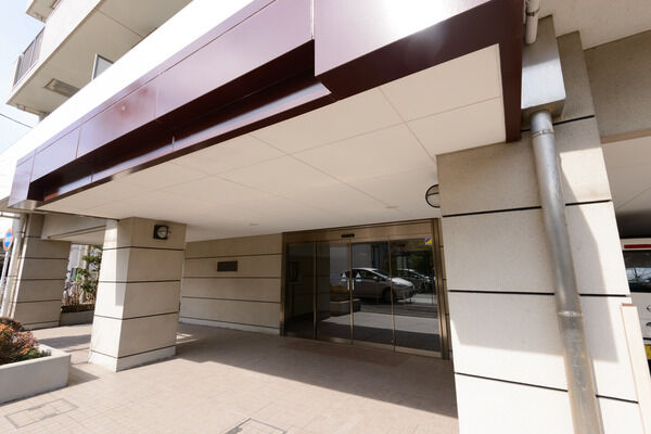 大きな目のタイルが配されたアプローチはガラス張りのドアと相まって上品な雰囲気。