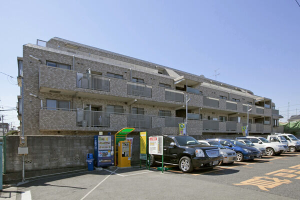 【パークハイム綱島】隣接駐車場からは壁で仕切られ、セキュリティー対策が施されている。		