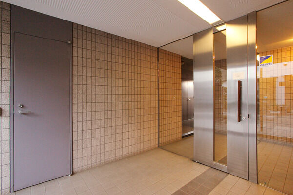 壁にタイルを施したエレガントなエントランス。		