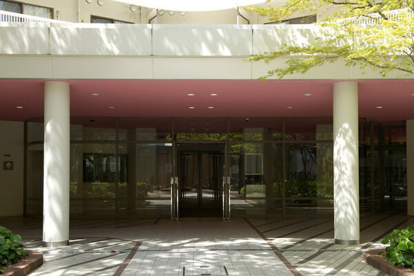 淡い桃色をアクセントに、ガラス張りのエントランスが住まう人の品格を表す。